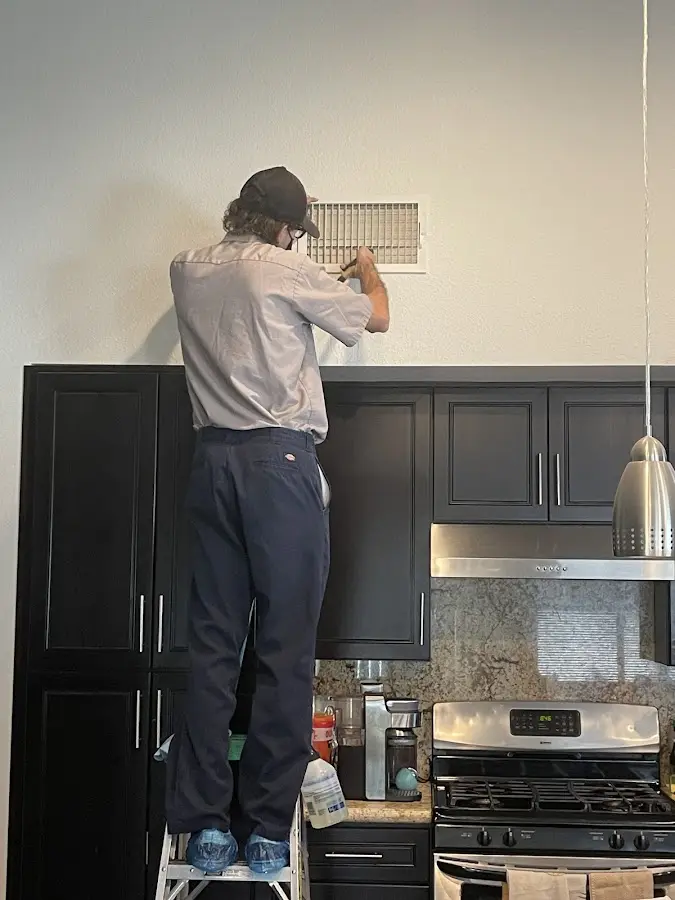Technician inspecting an air vent during HVAC service in Ephrata